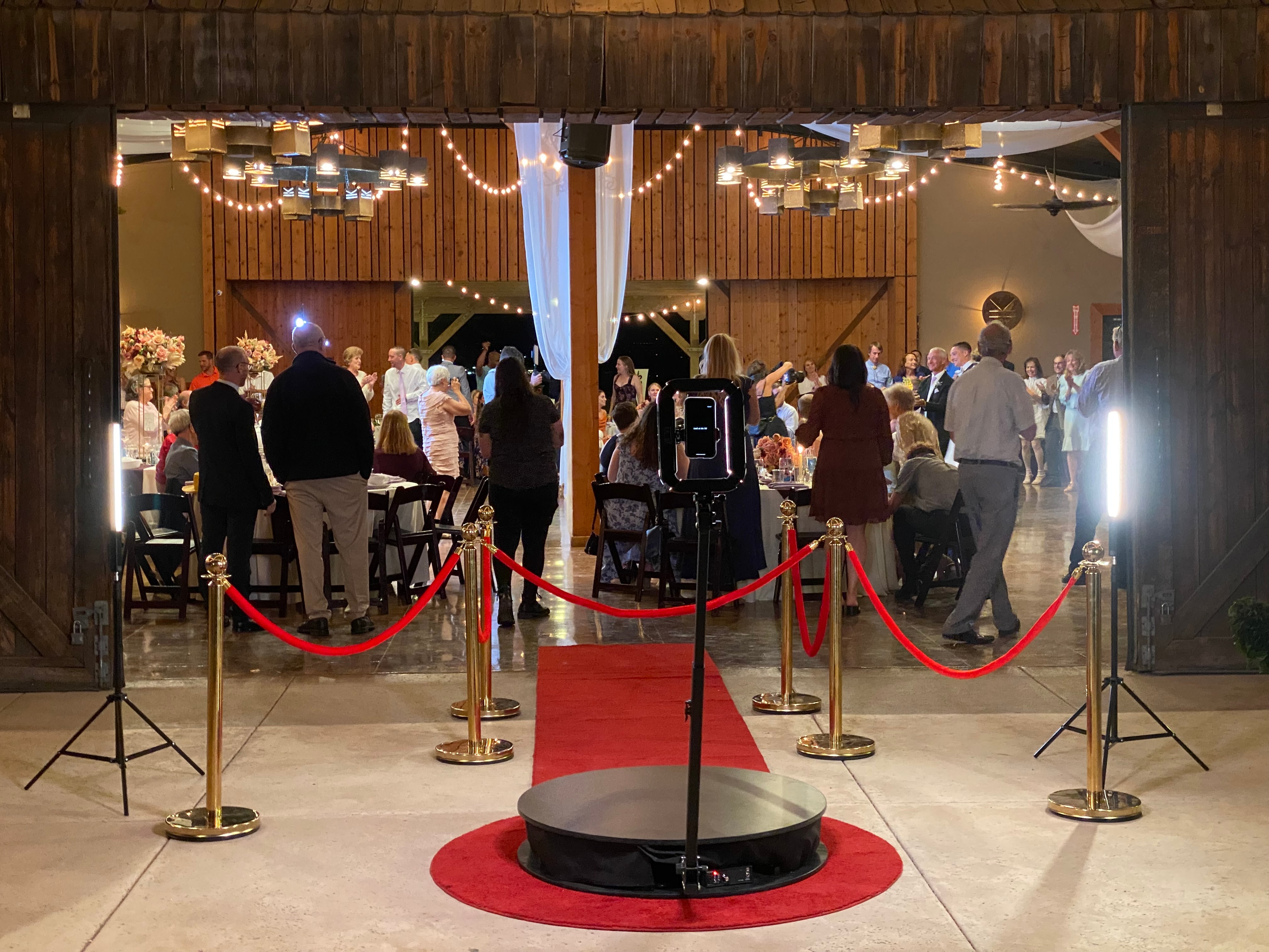 OrcaVue 360 photo booth platform at a professional event with red carpet and stanchions